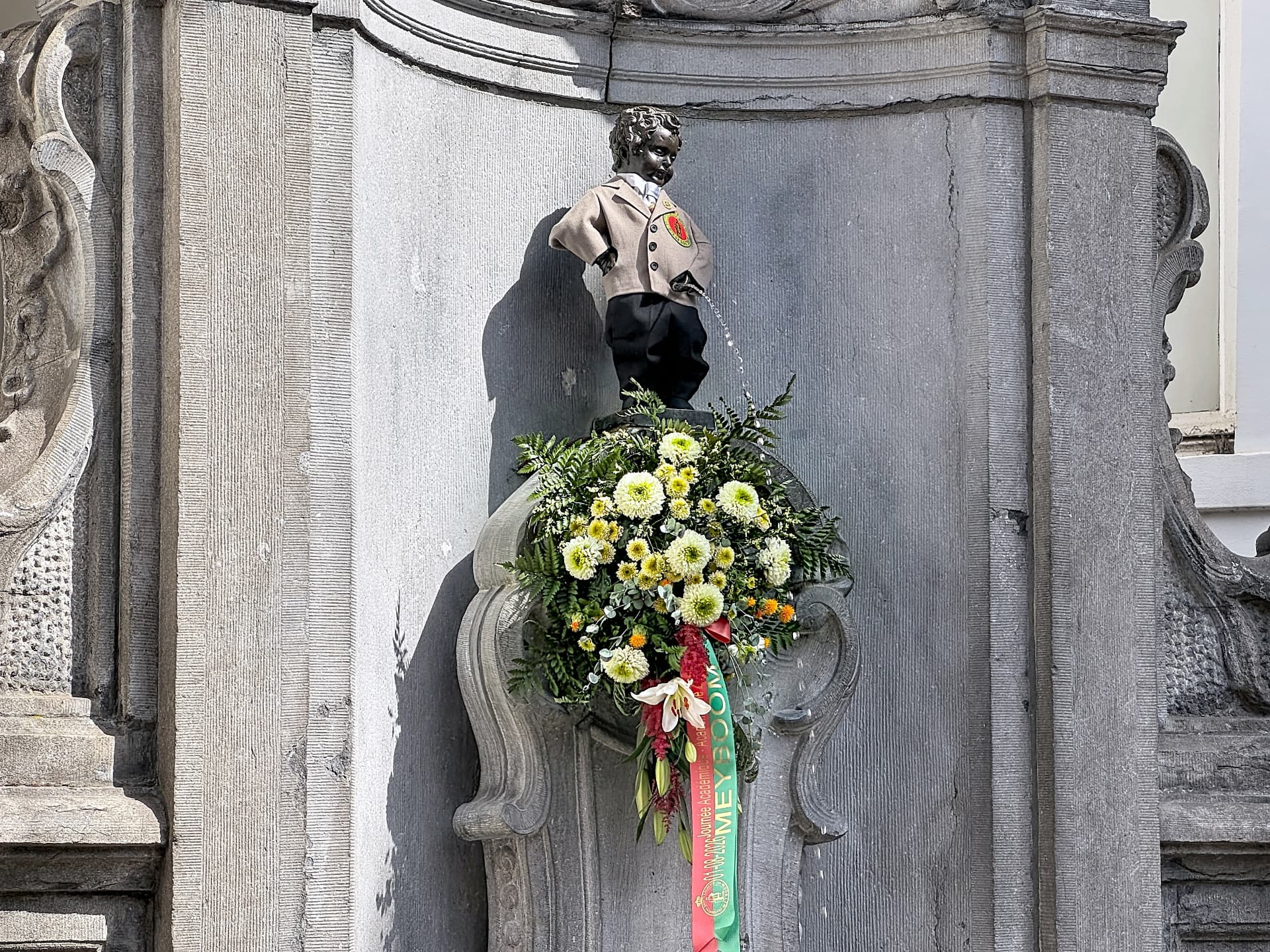 Statue du Manneken-Pis à Bruxelles, vêtue d'un costume traditionnel et ornée de fleurs
