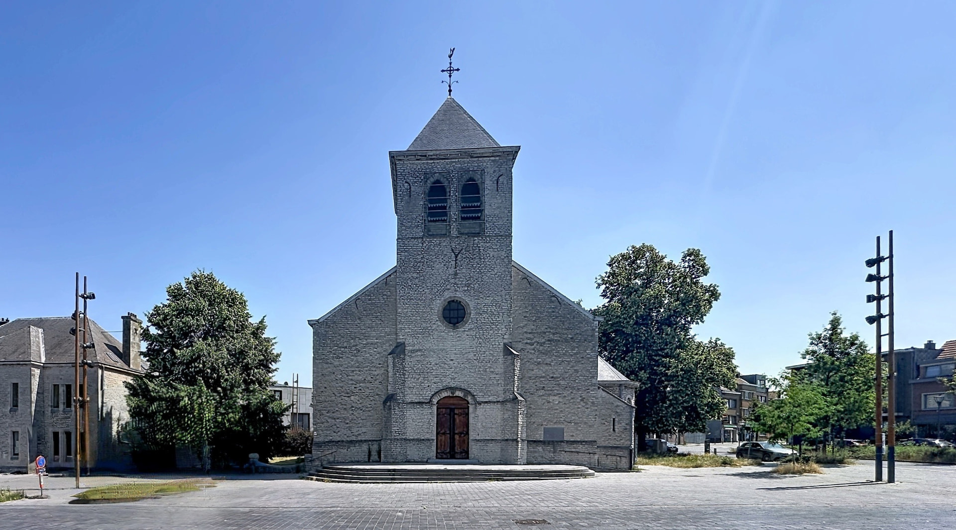 L'église Saint-Vincent en pierre claire sur sa place pavée, cœur du village d'Evere