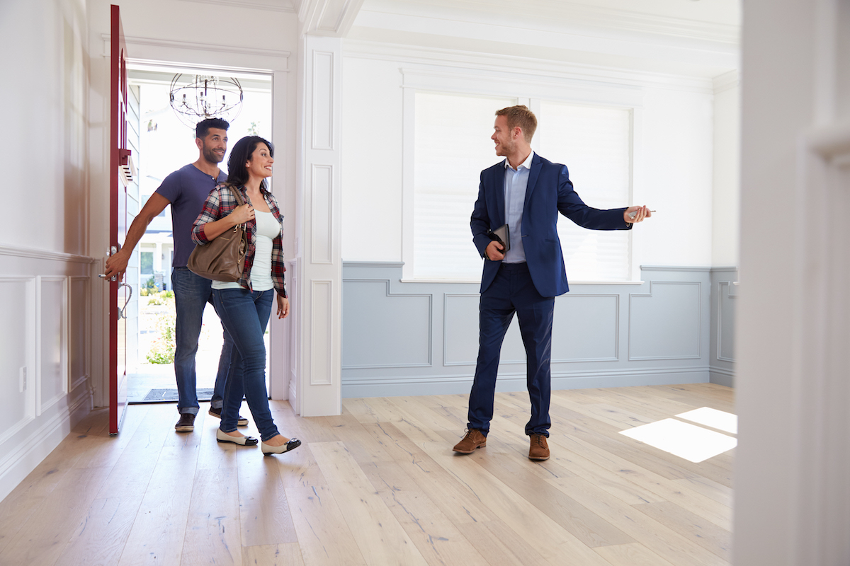 Agent immobilier accueillant des visiteurs dans une maison