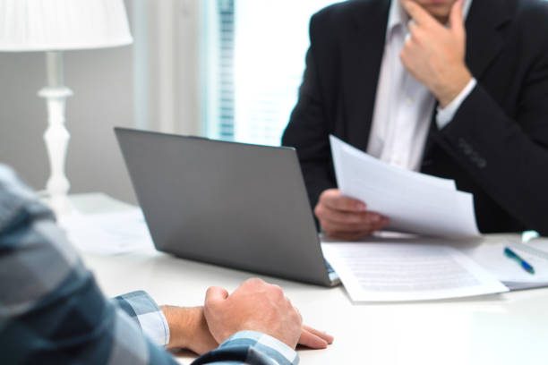 Réunion professionnelle autour d’un bureau avec documents financiers et ordinateur portable