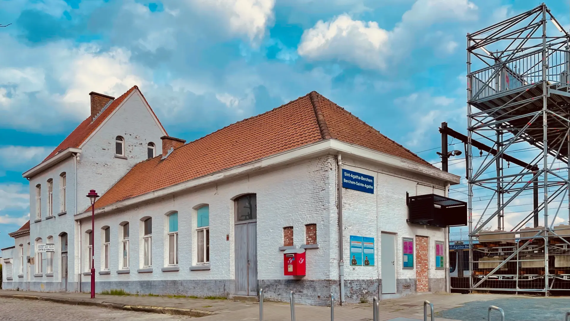 La gare de Berchem-Sainte-Agathe, bâtiment blanc au toit de tuiles