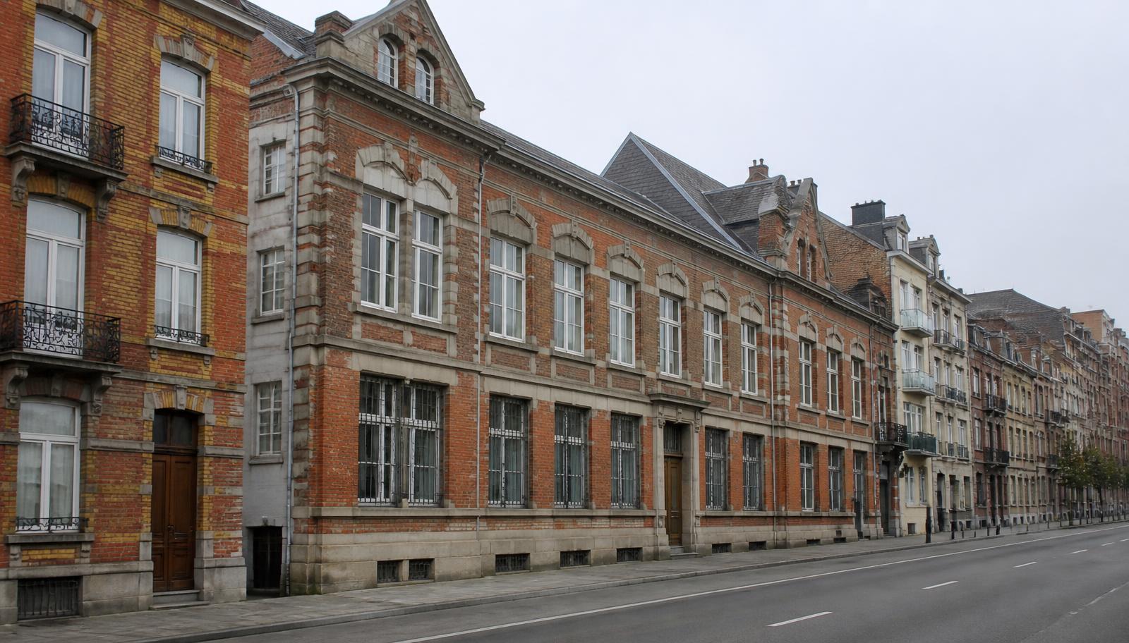 Grand bâtiment en briques et façades résidentielles à Schaerbeek