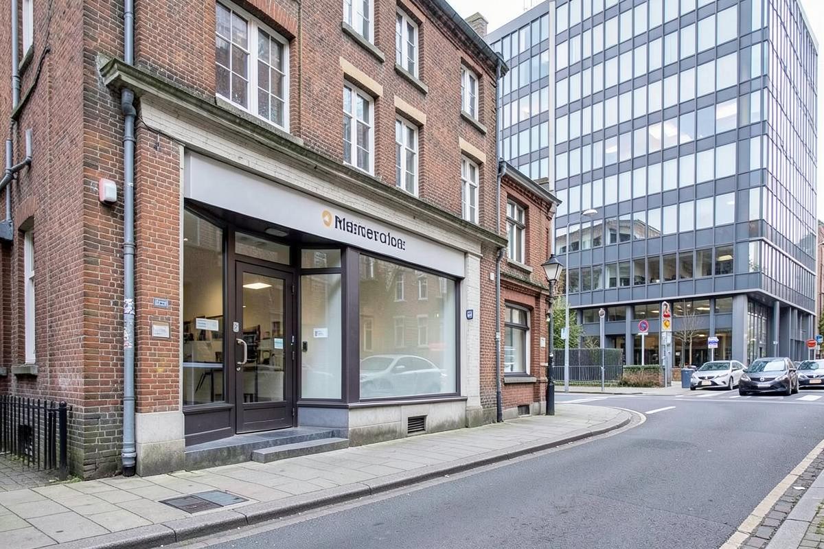 Bureau d'un syndic local bruxellois face à un immeuble de bureaux moderne